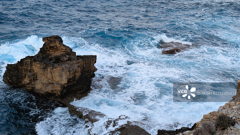 高角度拍摄，海浪拍打着戏剧性的岩石构造图片素材
