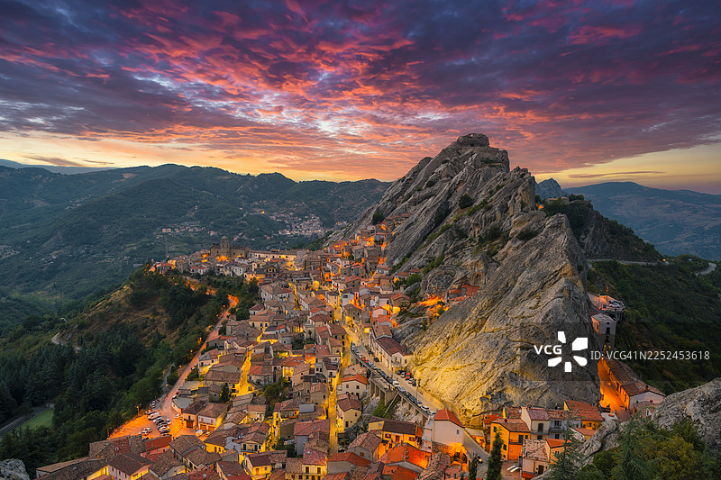 意大利巴西利卡塔地区，日落时分，皮埃特拉波尔齐亚山坡上的村庄与戏剧性的岩石构造相依图片素材