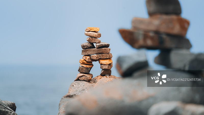 堆叠的石头特写，背景是宁静的大海，象征着平衡与正念，美国莫罗贝图片素材