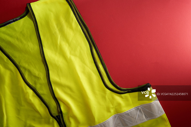 红色背景上的高可视度安全背心，象征着安全与警示图片素材