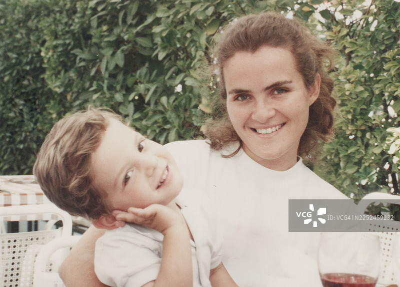20世纪80年代拍摄：一位年轻的女士微笑着，她的儿子正看着镜头，两人一同入镜图片素材