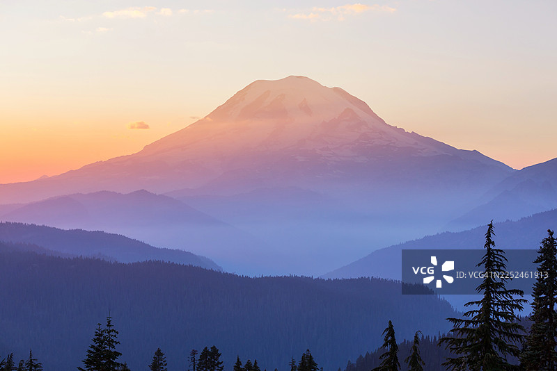 夕阳下的壮丽山景，天空色彩斑斓，森林轮廓分明图片素材