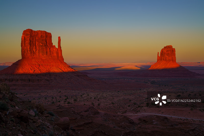 美国纪念碑谷州立公园，位于凯恩塔，标志性的孤峰和沙漠景观上空壮丽的日落图片素材