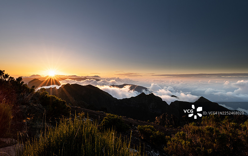 日出时令人惊叹的山地景观，云雾笼罩着山谷，展现出戏剧性的光影和自然之美，葡萄牙，马德拉图片素材
