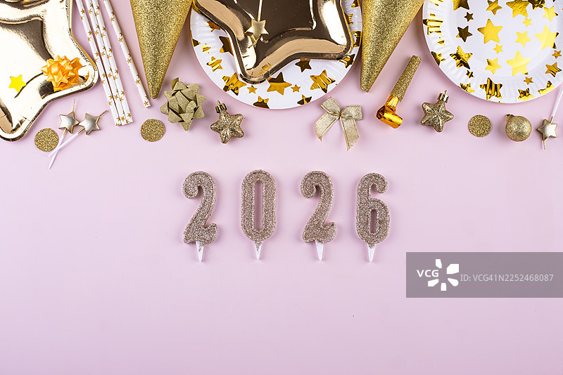 粉色背景上方的派对装饰和2026数字蜡烛的俯视拍摄，庆祝新年夜或生日图片素材