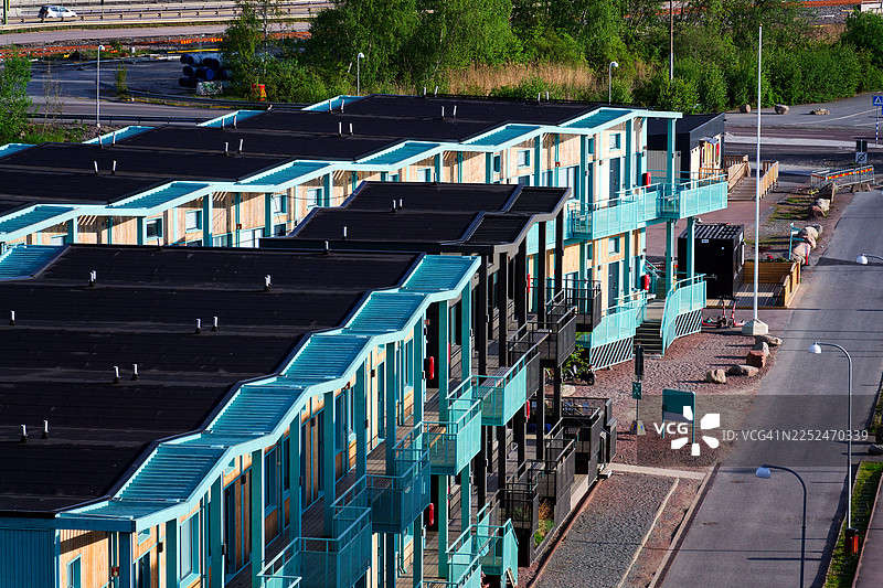 高角度拍摄的现代公寓楼，拥有青绿色阳台和黑色屋顶，位于瑞典哥德堡的城市环境中图片素材