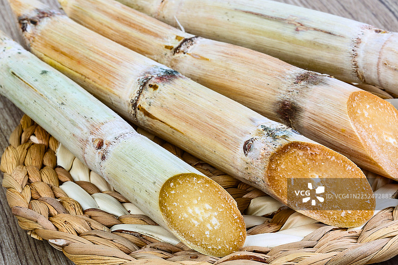 特写镜头，展示编织篮中新鲜切开的甘蔗茎，突出其天然质地和甜蜜的潜力图片素材