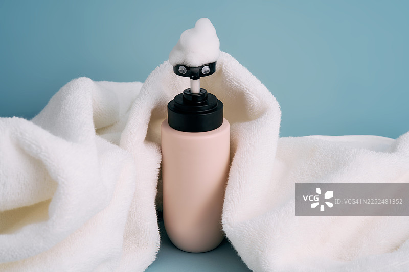 蓝底上可爱的泡沫皂液器和毛巾图片素材