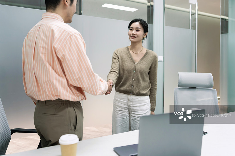 亚洲的商务同事在办公室会议室握手达成协议。图片素材