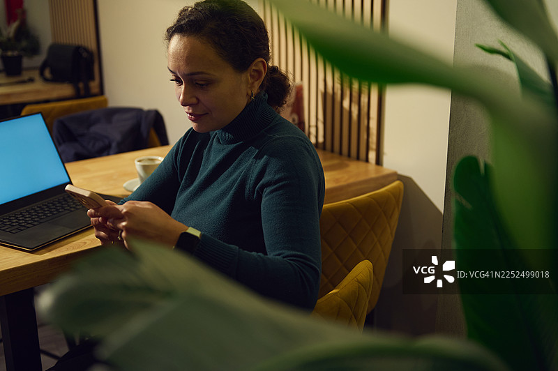 一位女士在安静的早晨咖啡休息时间，在舒适的豪华咖啡馆内远程工作，在线办公图片素材
