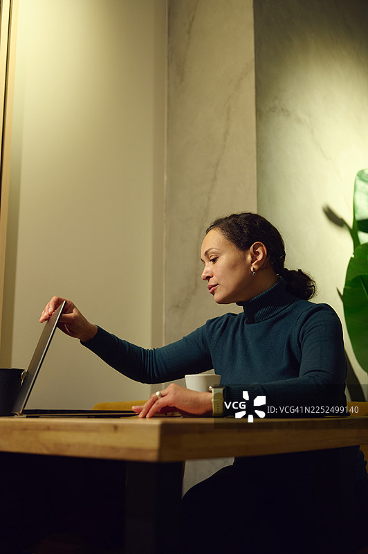 中东女性在时尚咖啡馆远程办公，用笔记本电脑在线工作图片素材