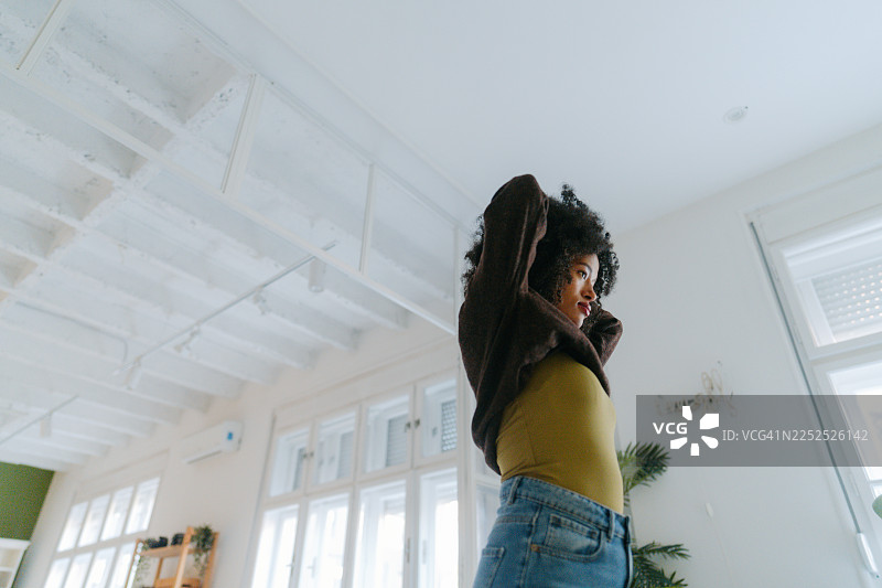 年轻女子在家中穿衣图片素材