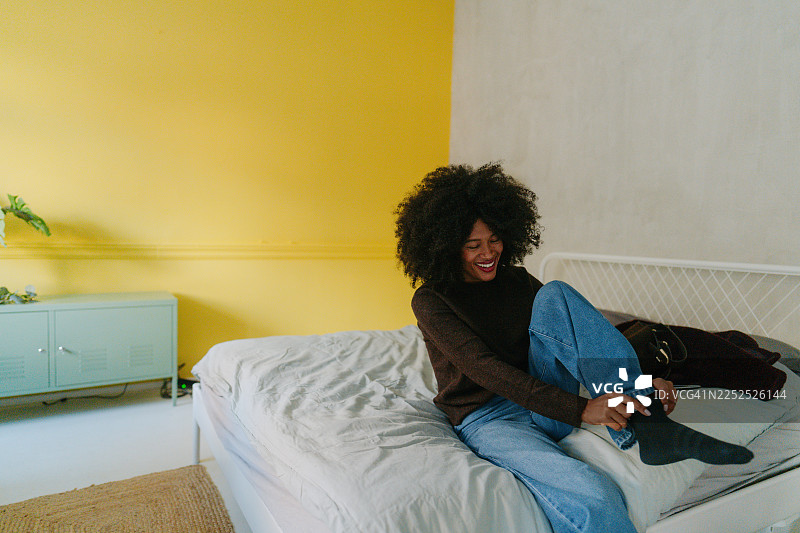 年轻女子在家中穿衣服图片素材