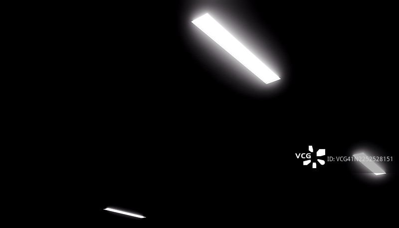 荧光灯在黑暗的黑色天花板上发光图片素材