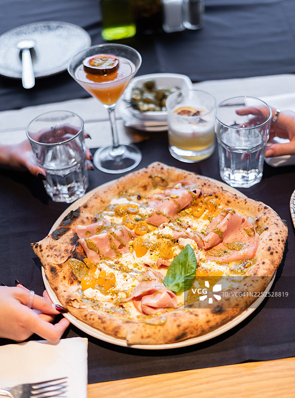 餐厅餐桌上美味的莫泰德拉香肠和香蒜酱披萨图片素材