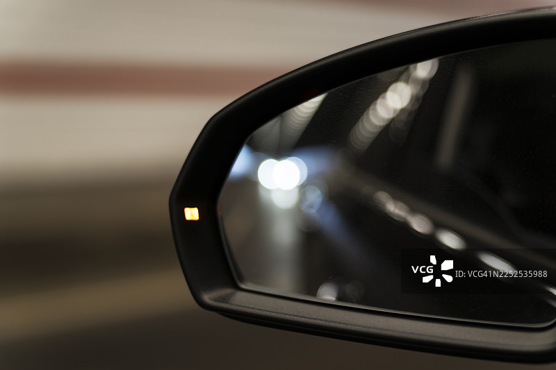 夜间城市隧道内车后视镜反射的交通信号灯图片素材