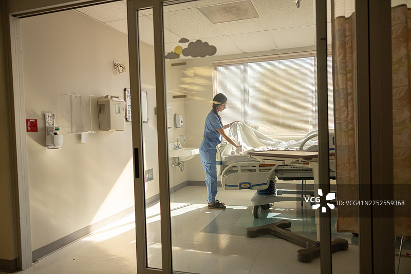 拉丁裔护士在医院重症监护室准备病床图片素材