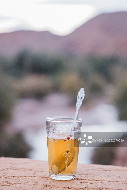 背景是山脉和水，一杯传统的薄荷茶图片素材