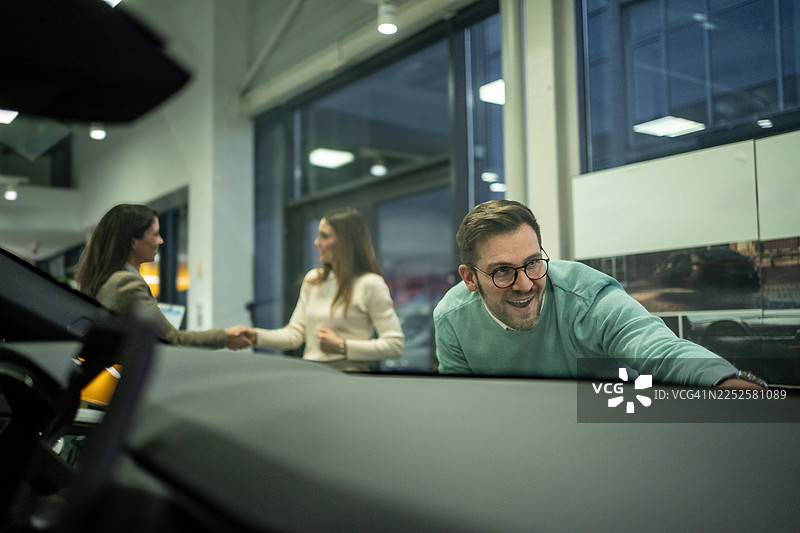 情侣在销售人员敲定交易时检查新车图片素材