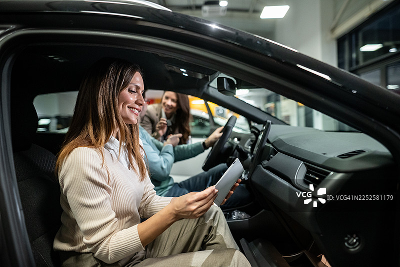 快乐的夫妇在展厅购买新车图片素材