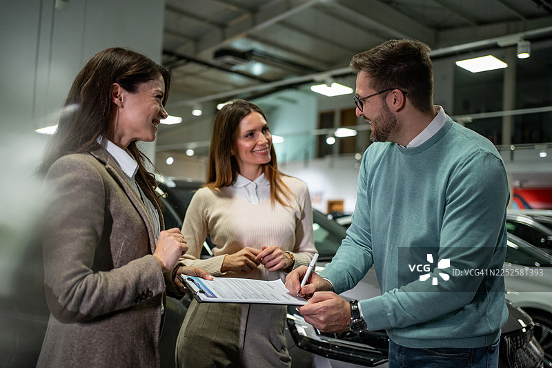 人们在经销商处签署购车协议图片素材