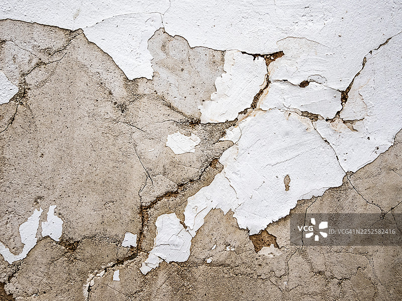 外墙涂成白色，因潮湿而剥落、破损并出现裂缝。图片素材
