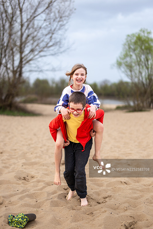 哥哥背着妹妹在海边图片素材