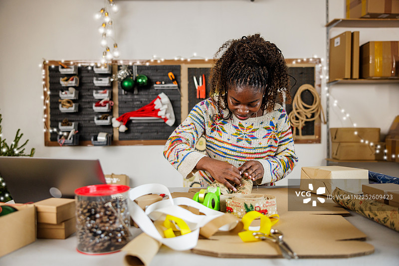 创意年轻女子在工作室包装礼物图片素材