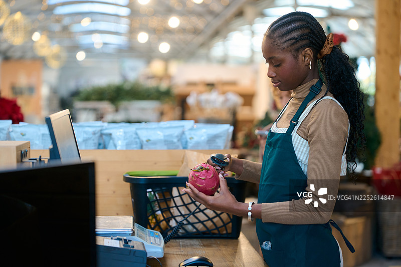 女收银员在超市结账处扫描火龙果图片素材