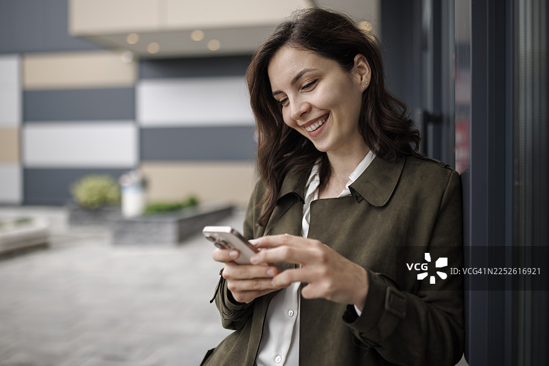 年轻女商人办公室外发短信图片素材