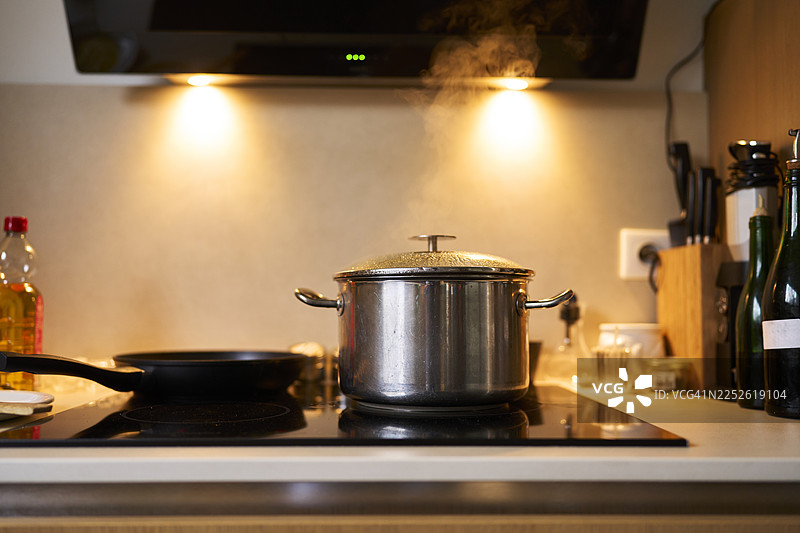 现代厨房炉灶上冒着热气的锅图片素材