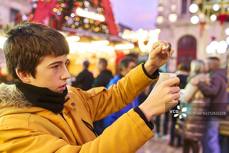 年轻人在集市上将巧克力倒入热饮中图片素材