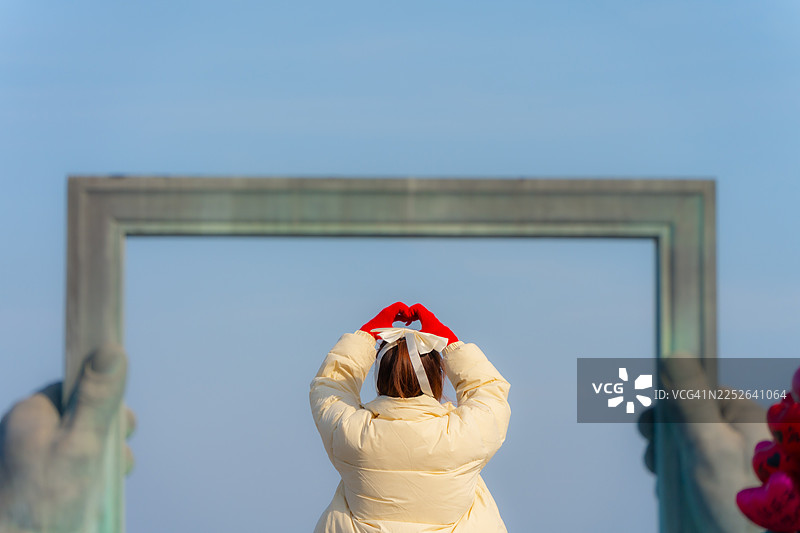 年轻女子在威海雕塑前旅行图片素材