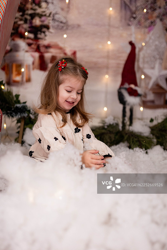 小女孩在圣诞节拍摄中玩人造雪图片素材