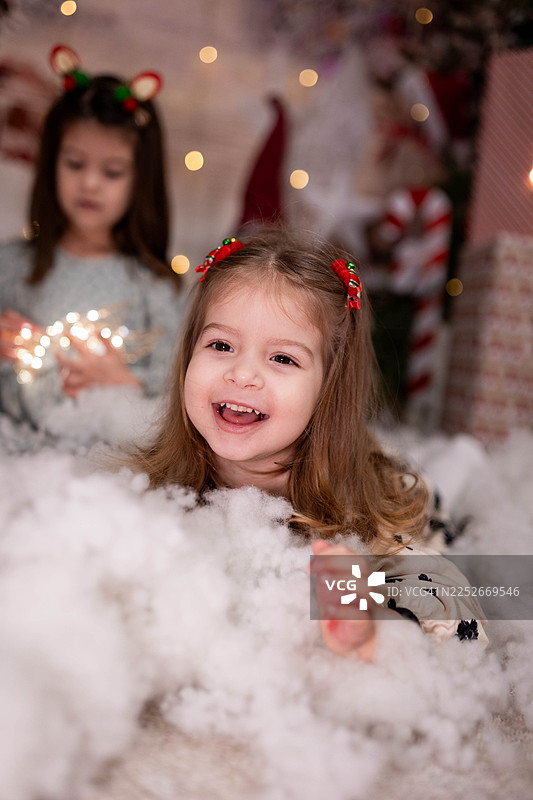 小女孩在圣诞节拍摄中玩人造雪图片素材