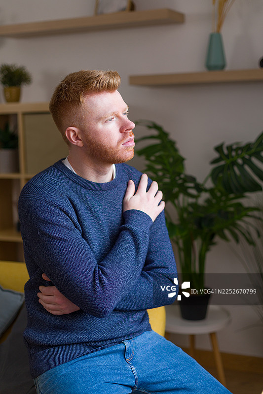 红发男子在家沉思，感到担忧图片素材