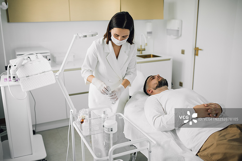 医生诊所里的男性病人。在手术前躺在治疗床上。图片素材