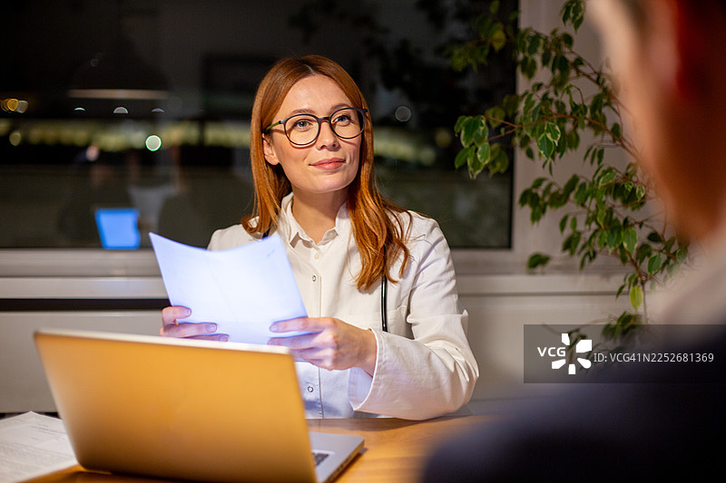 夜间诊所，医生正在咨询病人并讨论病历图片素材