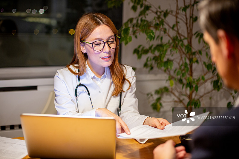女医生向男病人解释医疗文件图片素材