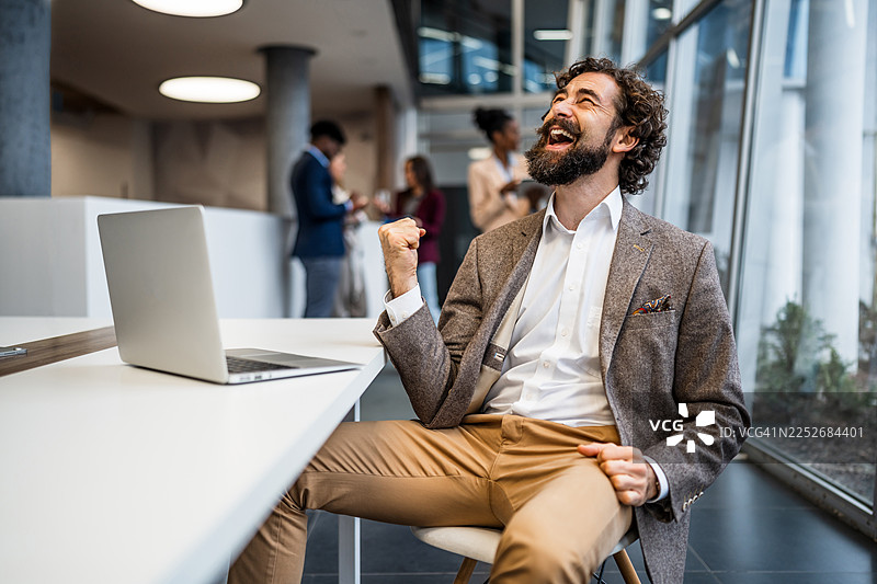 快乐的商界人士在现代办公室庆祝成功图片素材