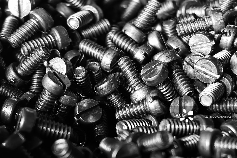 一堆黑色金属槽螺钉的全画幅特写图片素材