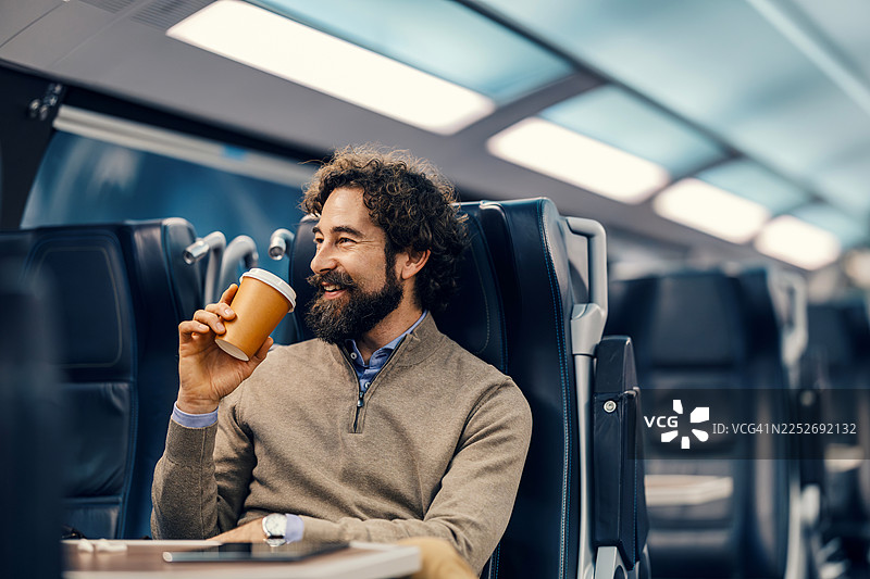 快乐的男人在火车旅行中享用咖啡图片素材