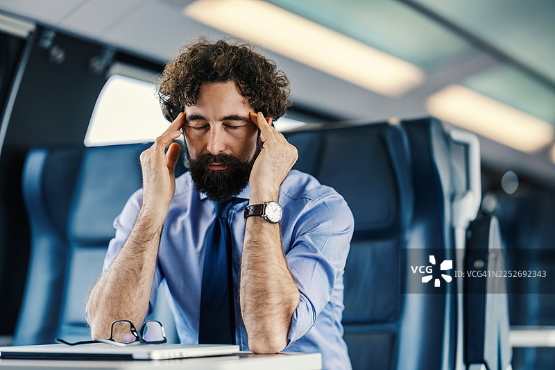 商务男士在火车上旅行时头痛图片素材