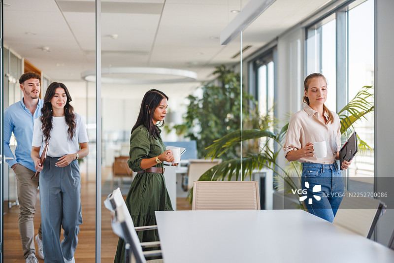 Z世代专业人士进入明亮的办公室进行协作会议图片素材