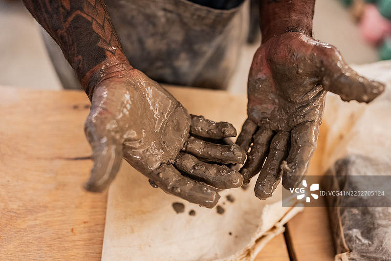 艺术课上，一位男士手上沾满了黏土图片素材