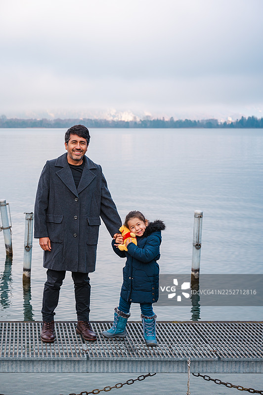 父亲与女儿在因特拉肯湖边共享天伦之乐图片素材