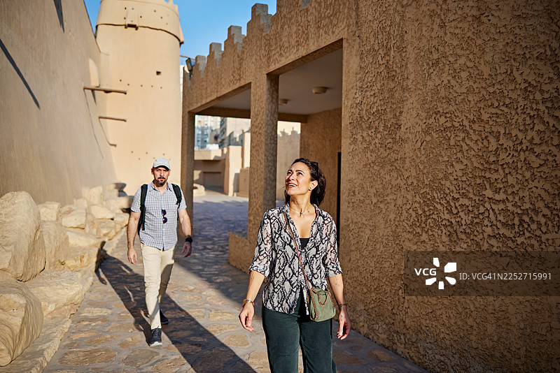 游客欣赏19世纪的纳吉泥砖建筑图片素材