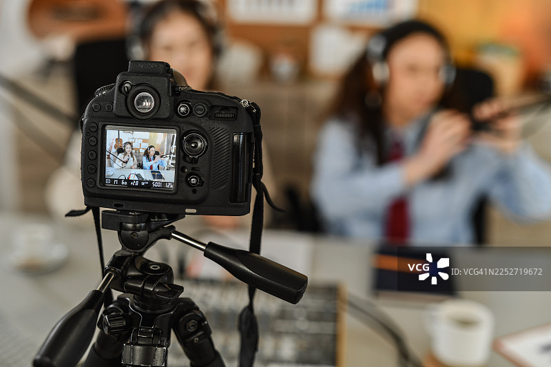 充满活力的播客录音棚场景，两位女士正在镜头前接受采访并开怀大笑图片素材