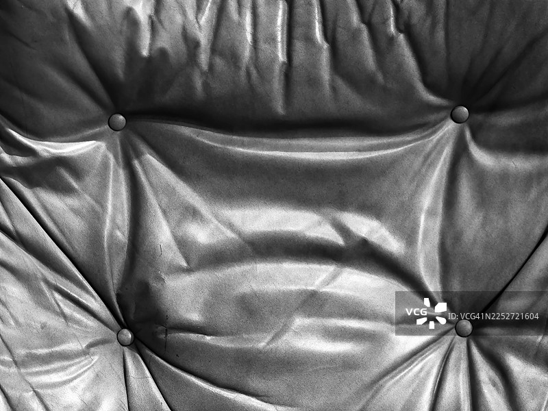 比利时布鲁塞尔，旧皮革皱纹沙发特写。日光。黑白。图片素材