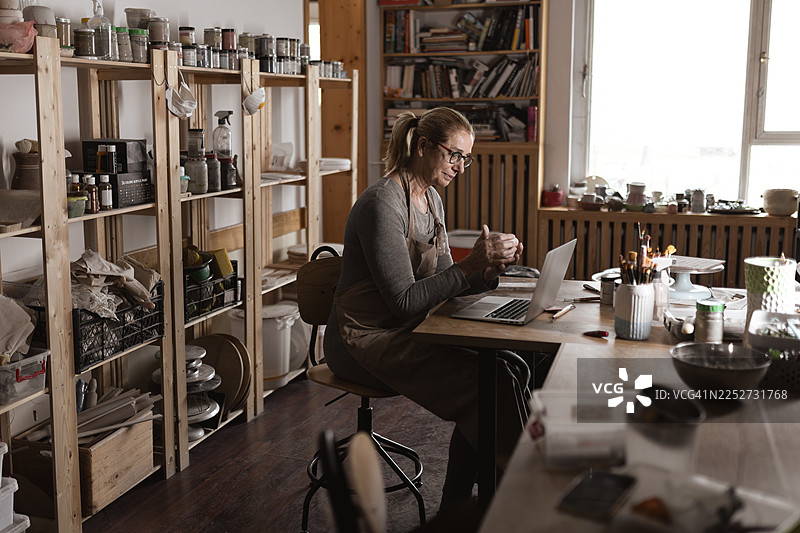 女陶艺师在陶艺工作室打理网店图片素材